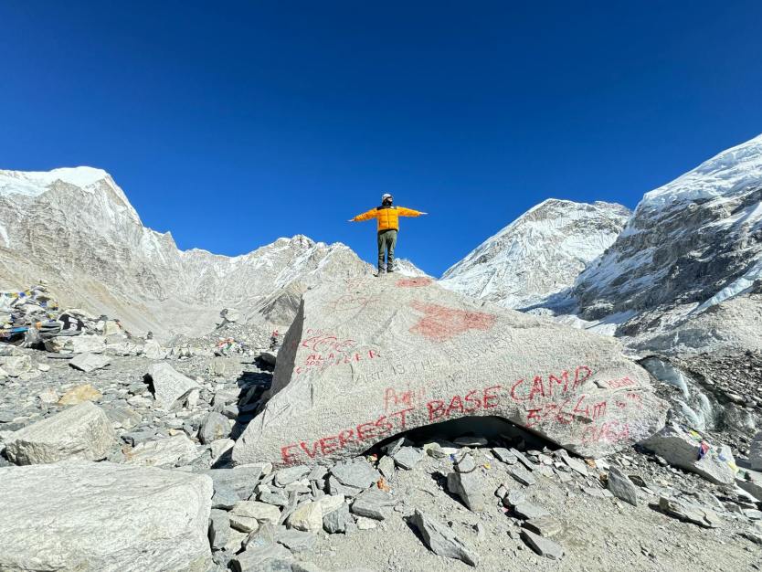 mountaineer posing on a rock at the everest base camp